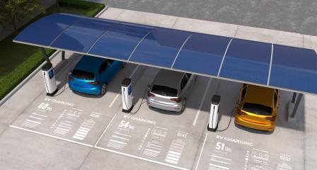 Carport solar fotovoltaico instalado sobre estacionamento com três veículos elétricos conectados a carregadores. A cobertura é formada por módulos fotovoltaicos e integra geração de energia solar à infraestrutura de carregamento de veículos elétricos. A solução demonstra como um estacionamento solar pode combinar carport fotovoltaico, mobilidade elétrica e recarga de carros elétricos, aproveitando a área das vagas para geração de energia e suporte à eletrificação de frotas.